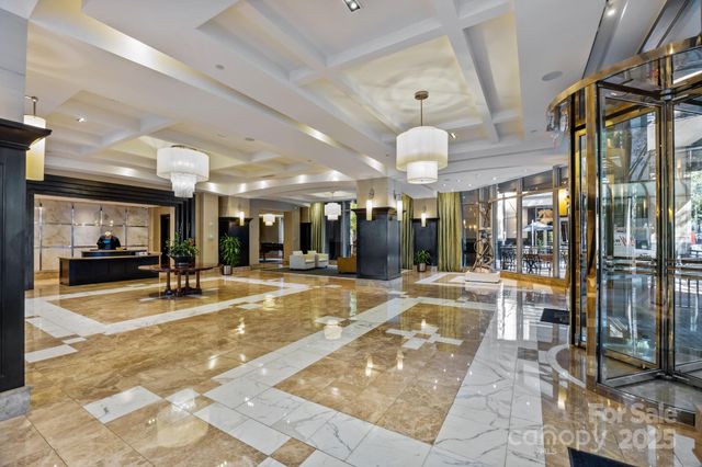 a view of a lobby with a chandelier and floor to ceiling windows