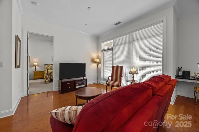a living room with furniture a flat screen tv and wooden floor