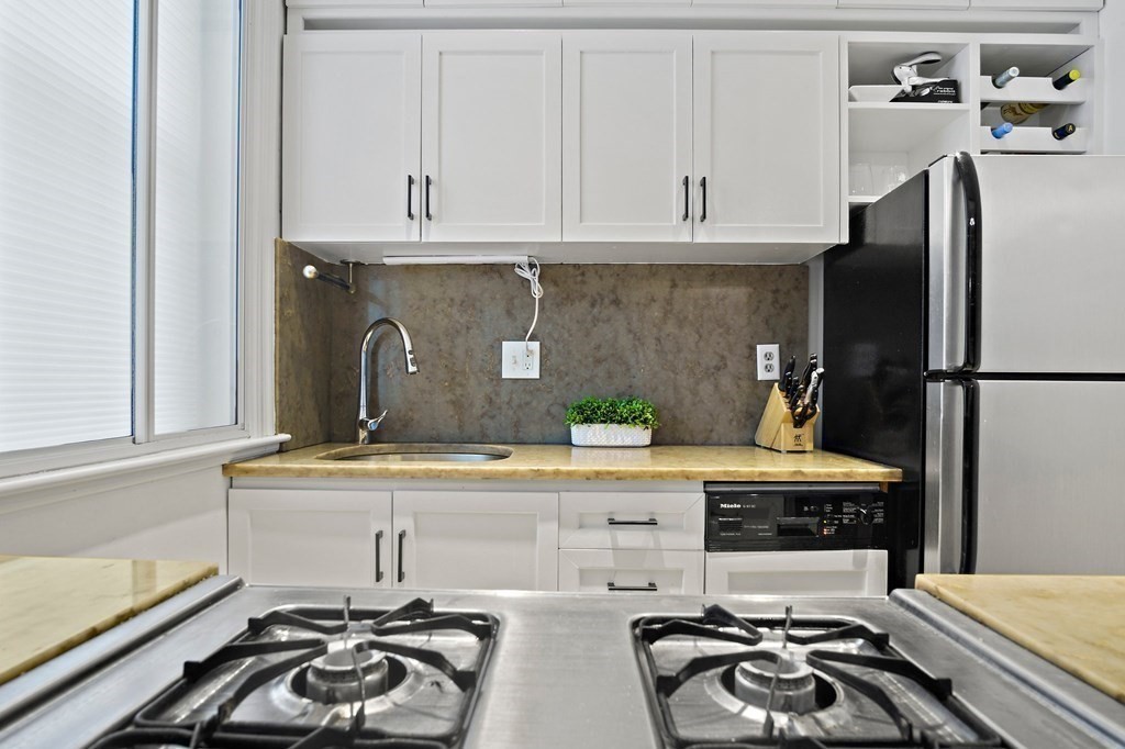 28 Everett Street, Unit 2 Boston, MA 02130 - Photo 13 of 25 a kitchen with stainless steel appliances a sink and cabinets