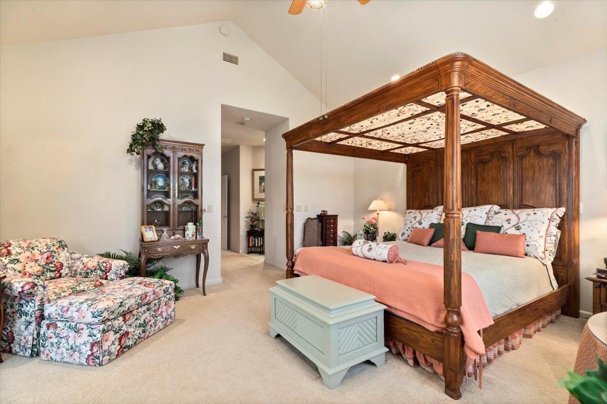 4558 Country View Court Cool, CA 95614 - Photo 38 of 82 a bedroom with a large bed and a chandelier