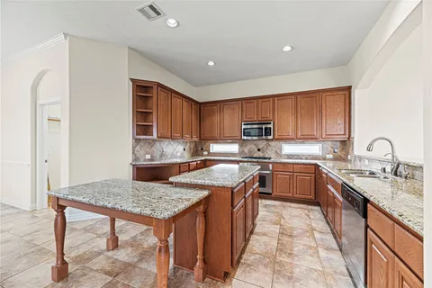 a kitchen with a stove sink and cabinets