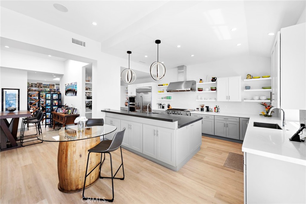 a kitchen with stainless steel appliances kitchen island granite countertop a sink cabinets and wooden floor