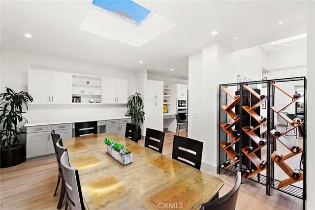 a kitchen with stainless steel appliances a refrigerator a stove a dining table and chairs