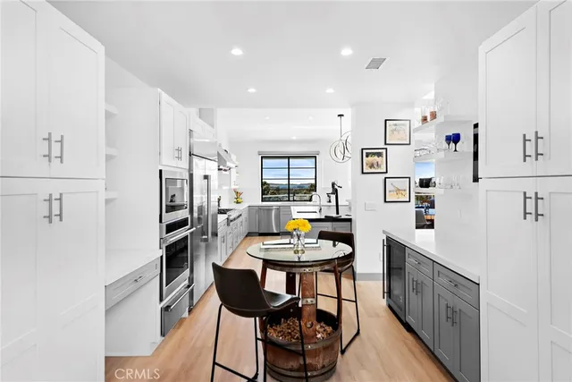 a kitchen with stainless steel appliances a stove a table and chairs
