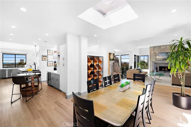 a kitchen with stainless steel appliances a refrigerator a stove a dining table and chairs with wooden floor