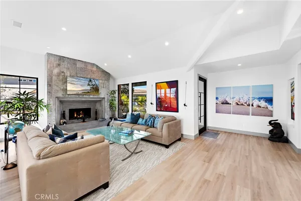 a kitchen with stainless steel appliances a refrigerator a stove a dining table and chairs with wooden floor