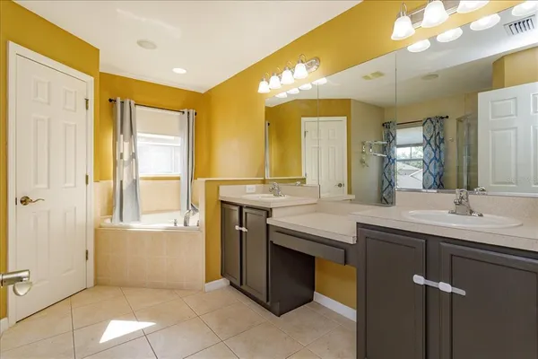 a bathroom with a granite countertop sink a mirror and a bathtub