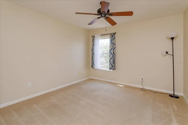 an empty room with windows and fan