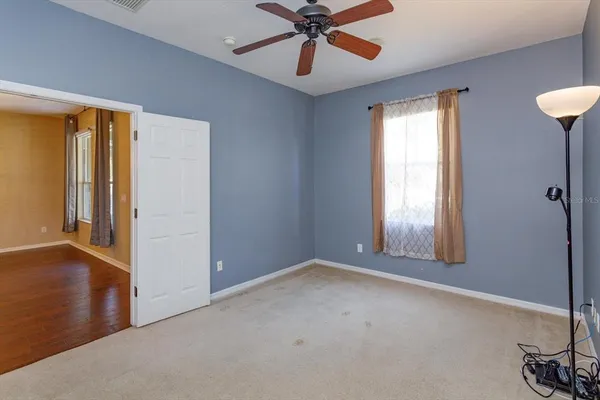 an empty room with windows and fan