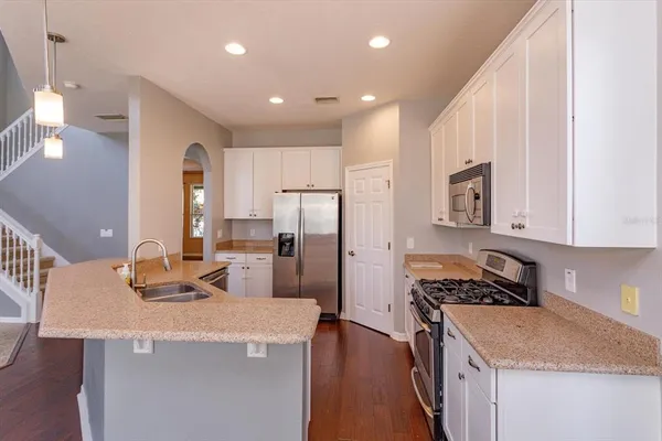 a kitchen with granite countertop a sink stove and refrigerator