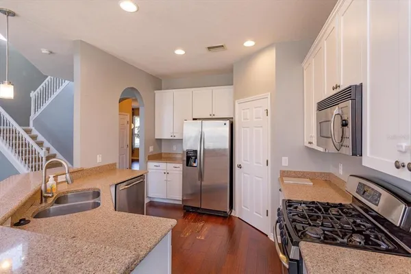 a kitchen with stainless steel appliances granite countertop a sink stove and refrigerator