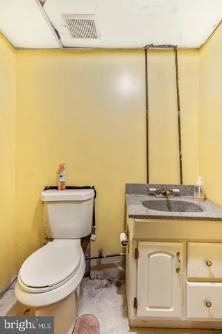 a bathroom with a granite countertop toilet and a sink