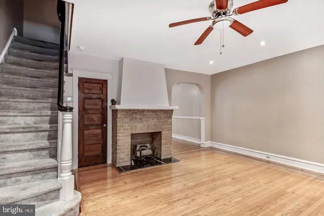 an empty room with windows and fireplace