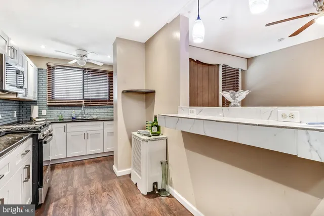 a kitchen with a sink cabinets stainless steel appliances and a window