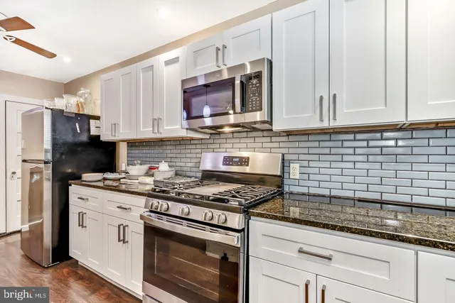 a kitchen with stainless steel appliances granite countertop a stove a microwave and a refrigerator