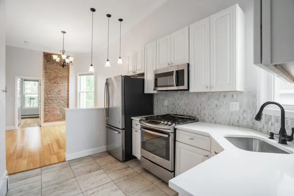a kitchen with stainless steel appliances granite countertop a refrigerator sink and stove