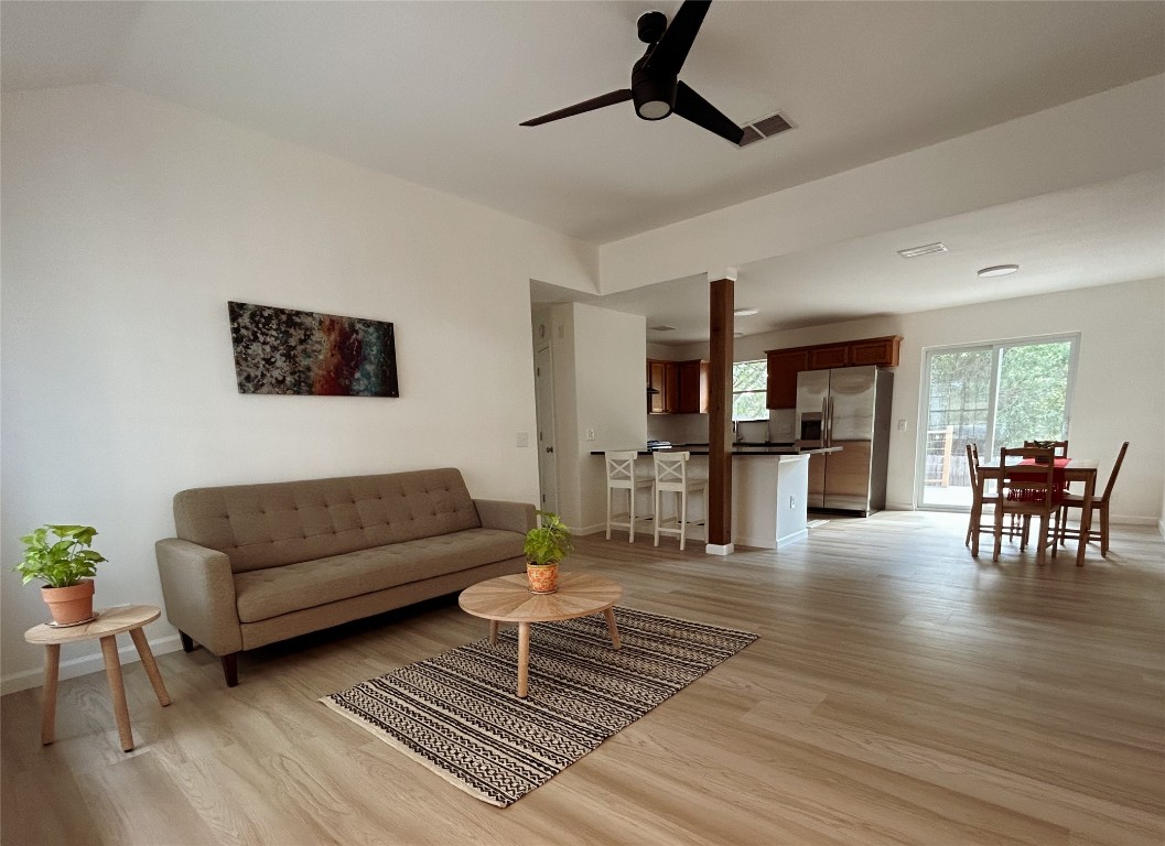 a living room with furniture and view of kitchen