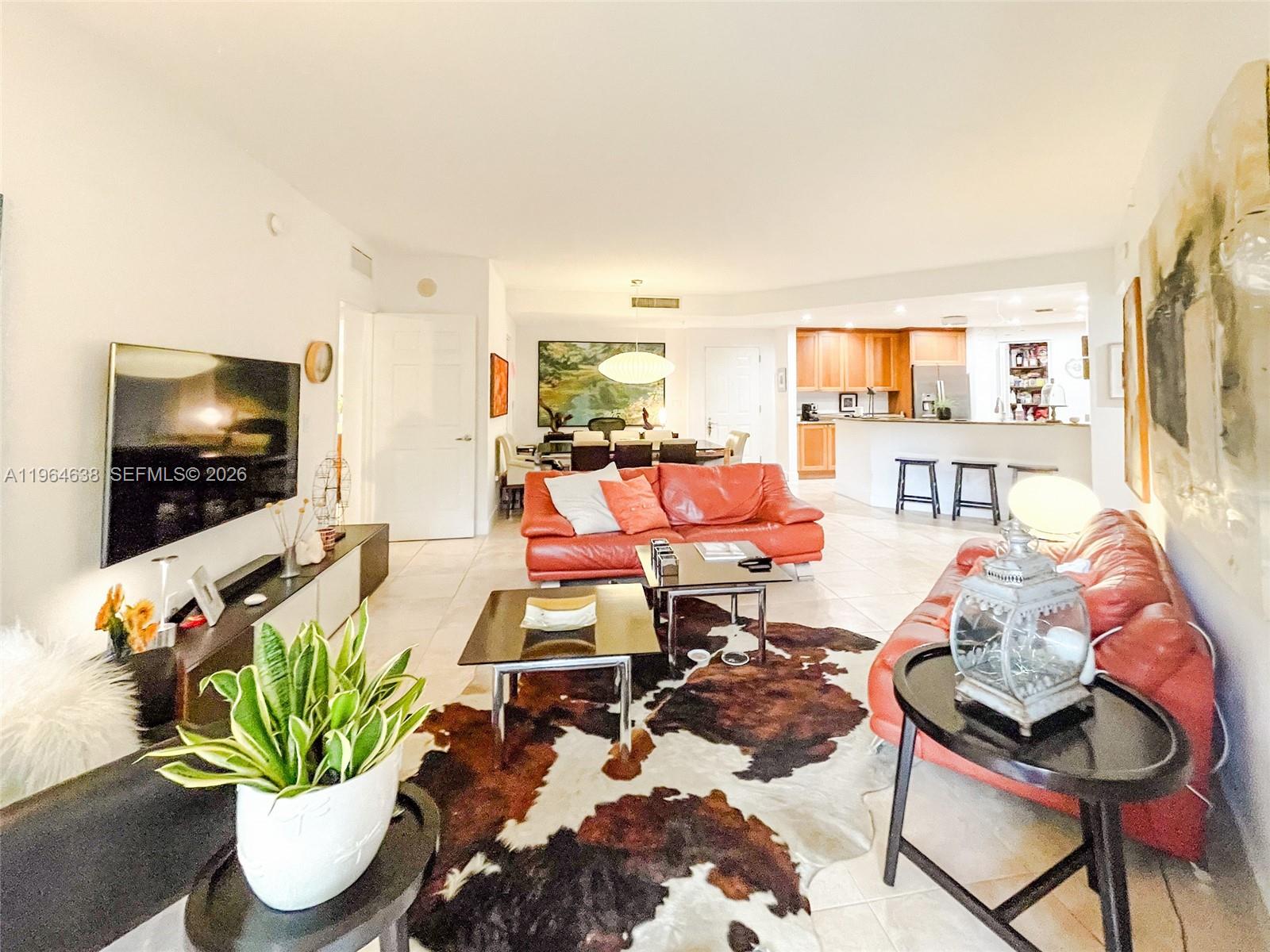 55 Merrick Way, Unit 715 Coral Gables, FL 33134 - Photo 1 of 52 a living room with furniture a flat screen tv and a potted plant