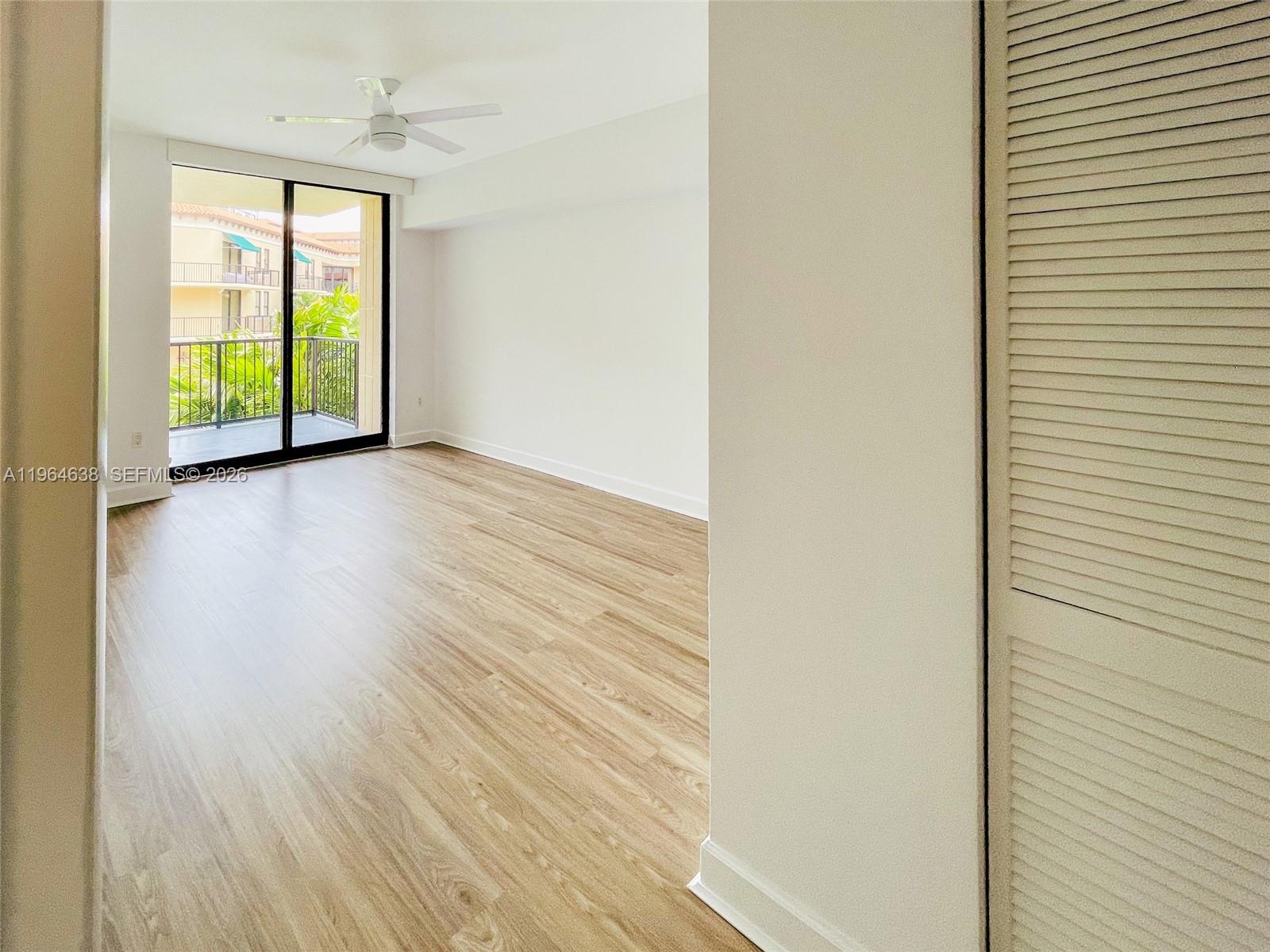 55 Merrick Way, Unit 715 Coral Gables, FL 33134 - Photo 11 of 52 a view of an empty room with wooden floor and a window