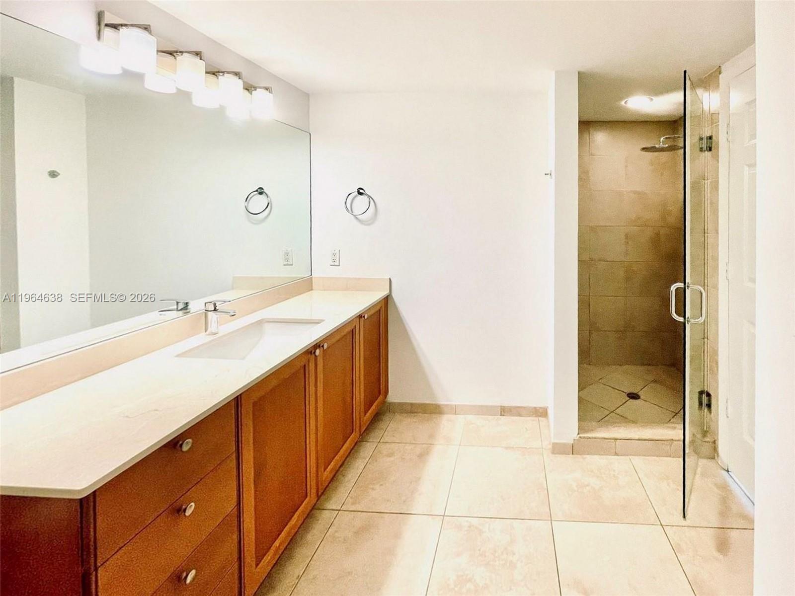 55 Merrick Way, Unit 715 Coral Gables, FL 33134 - Photo 15 of 52 a spacious bathroom with a shower sink and mirror