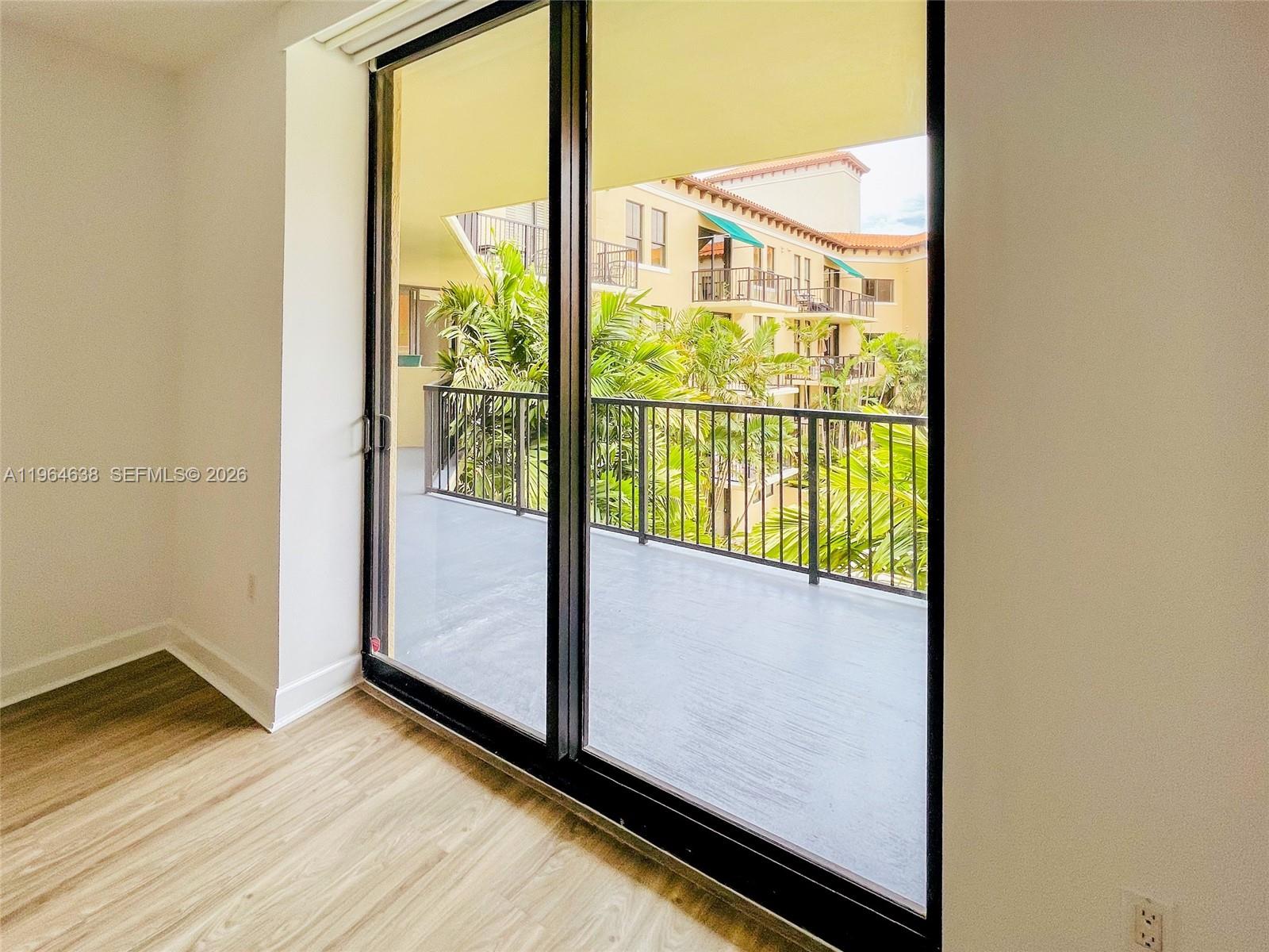 55 Merrick Way, Unit 715 Coral Gables, FL 33134 - Photo 21 of 52 an empty room with wooden floor and windows