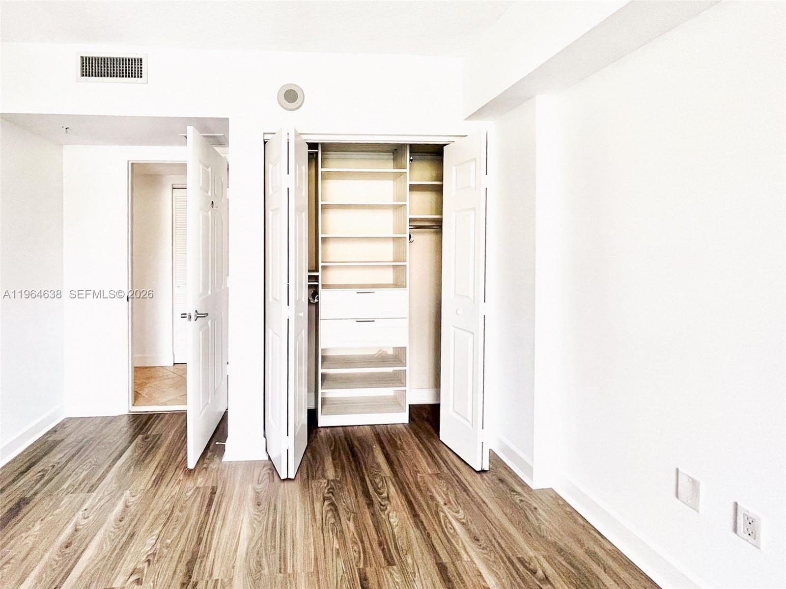 55 Merrick Way, Unit 715 Coral Gables, FL 33134 - Photo 22 of 52 a view of a bedroom with wooden floor and closet