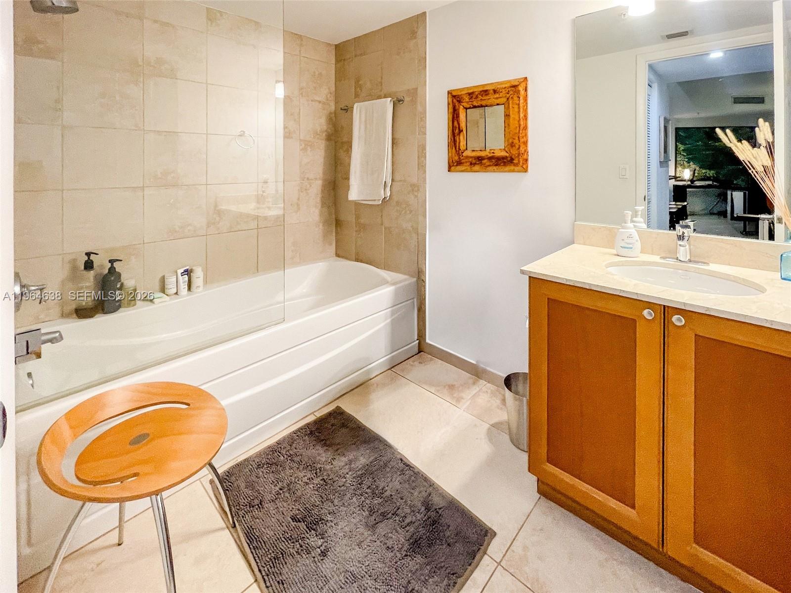 55 Merrick Way, Unit 715 Coral Gables, FL 33134 - Photo 23 of 52 a bathroom with a tub a sink and a mirror