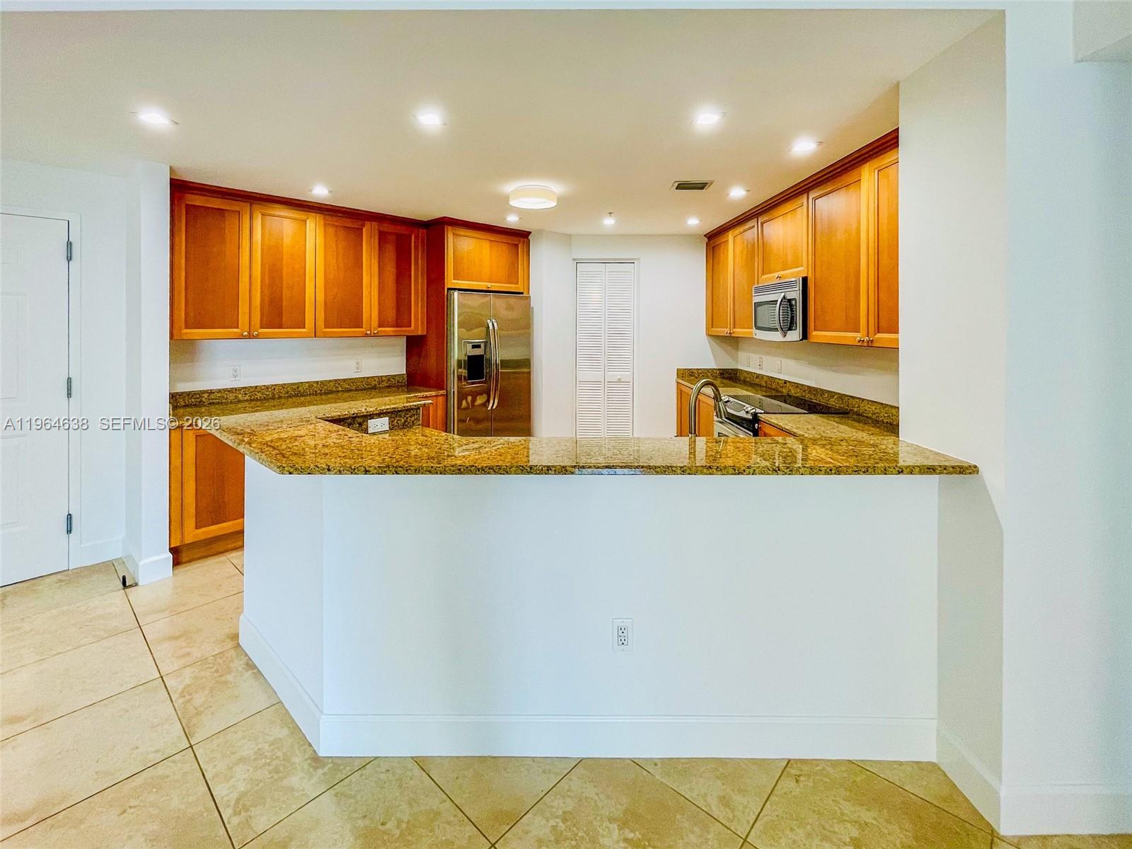 55 Merrick Way, Unit 715 Coral Gables, FL 33134 - Photo 27 of 52 a kitchen with stainless steel appliances granite countertop a sink a stove and a refrigerator