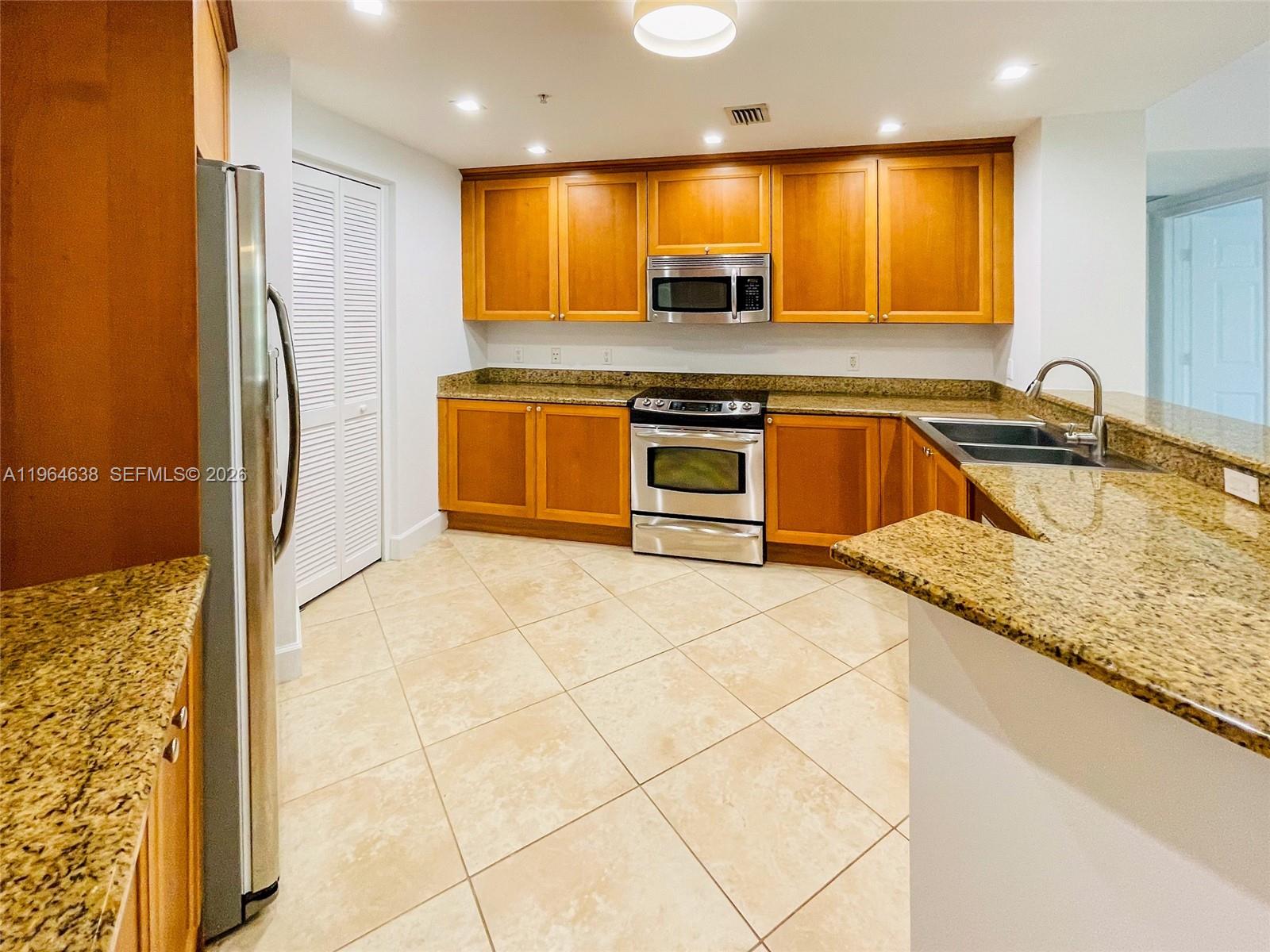 55 Merrick Way, Unit 715 Coral Gables, FL 33134 - Photo 29 of 52 a kitchen with stainless steel appliances granite countertop a sink and a refrigerator