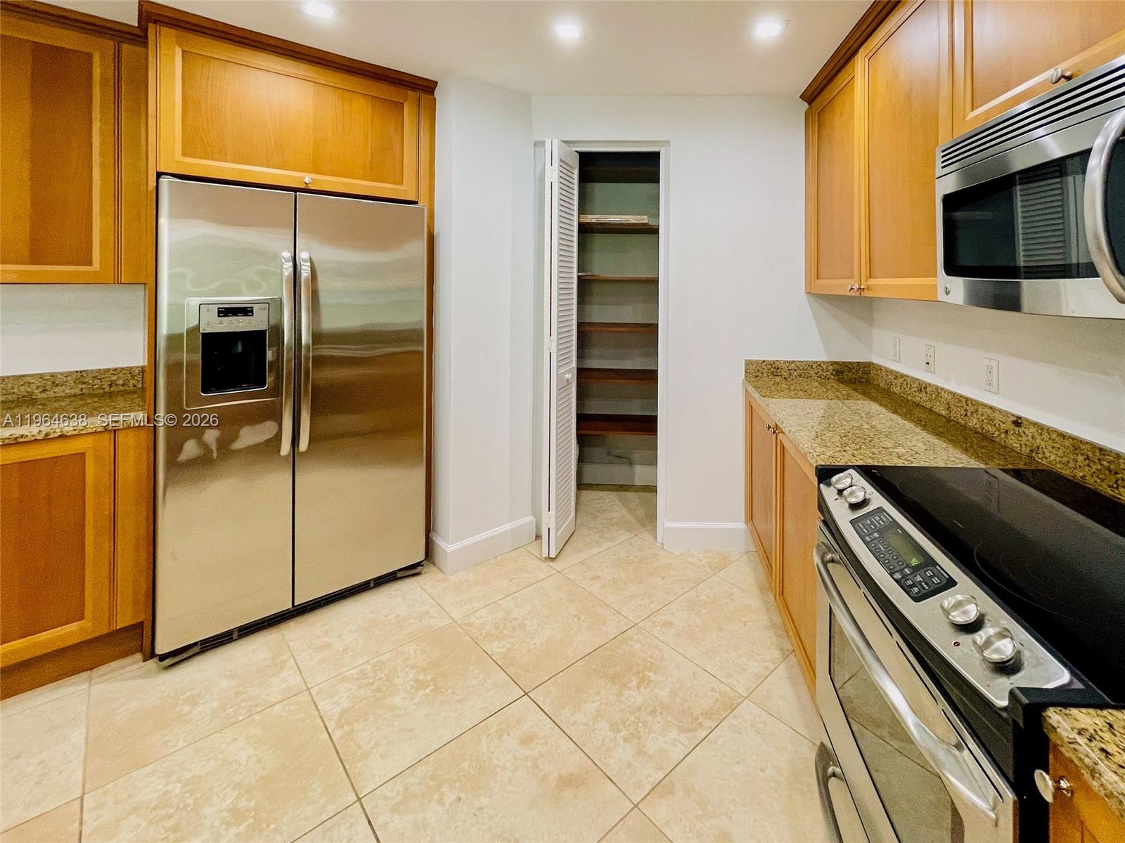 55 Merrick Way, Unit 715 Coral Gables, FL 33134 - Photo 31 of 52 a kitchen with stainless steel appliances granite countertop a refrigerator and a stove