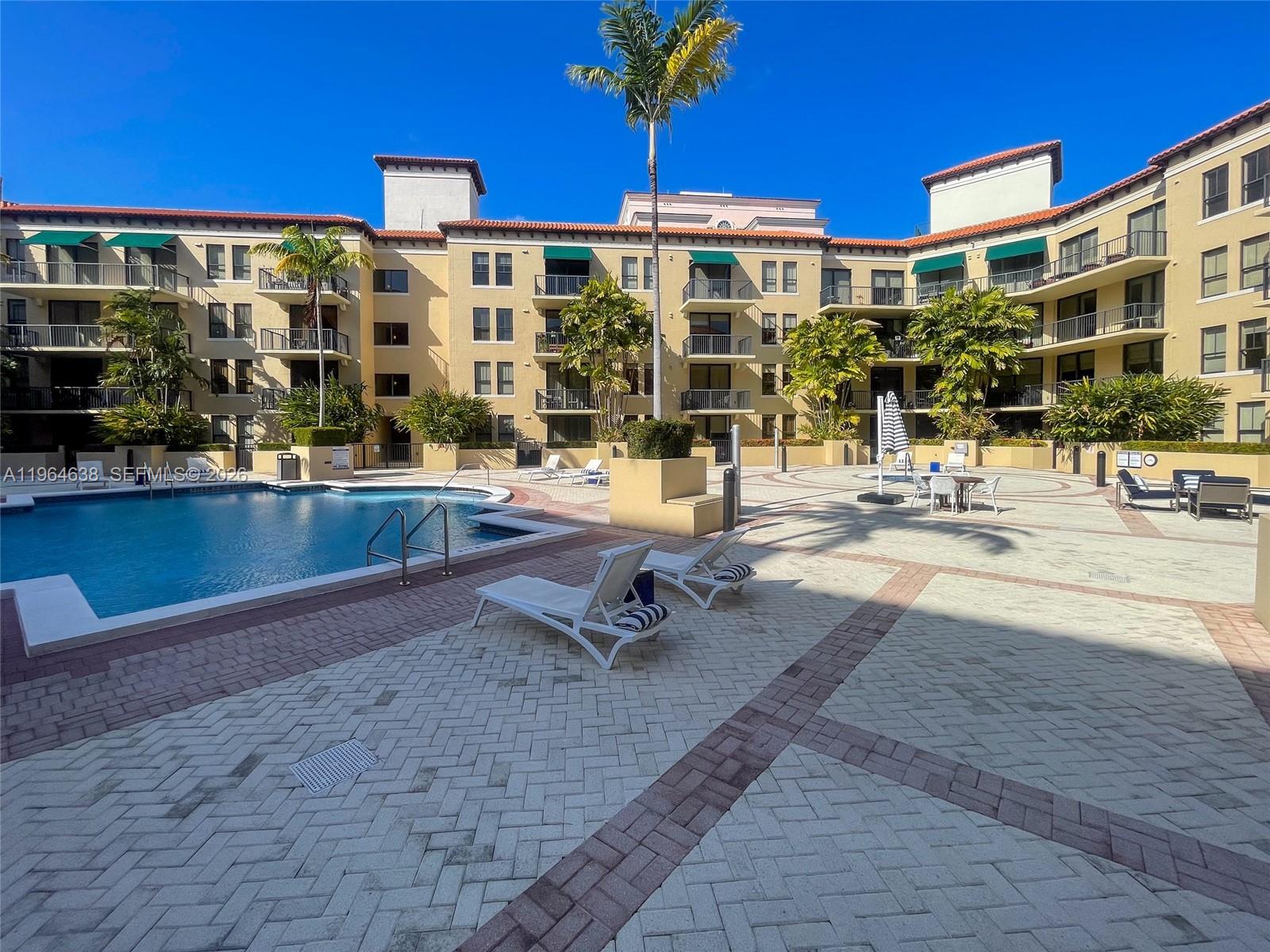 55 Merrick Way, Unit 715 Coral Gables, FL 33134 - Photo 38 of 52 a swimming pool with outdoor seating and yard