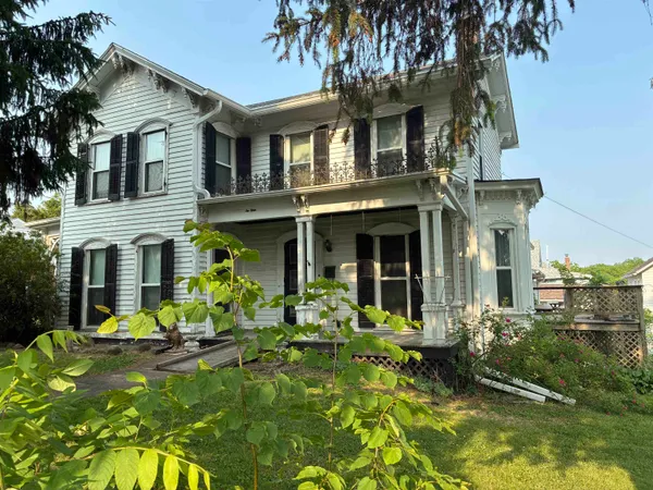 a kitchen with stainless steel appliances granite countertop a refrigerator a stove a sink a dining table and chairs with wooden floor