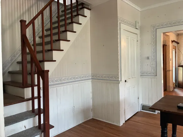 a view of a hallway with wooden floor and door