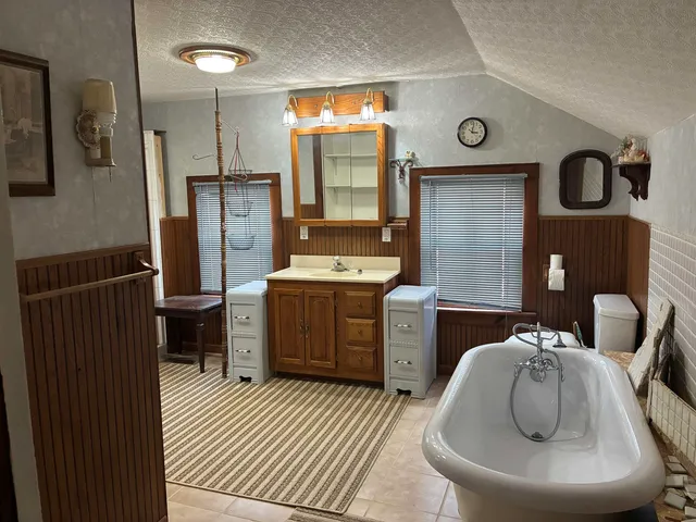 a bedroom with wooden floor and chandelier