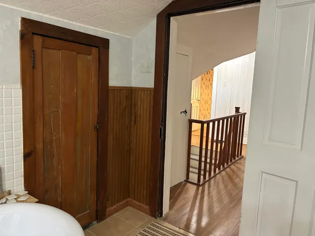 a view of a hallway with wooden floor and staircase