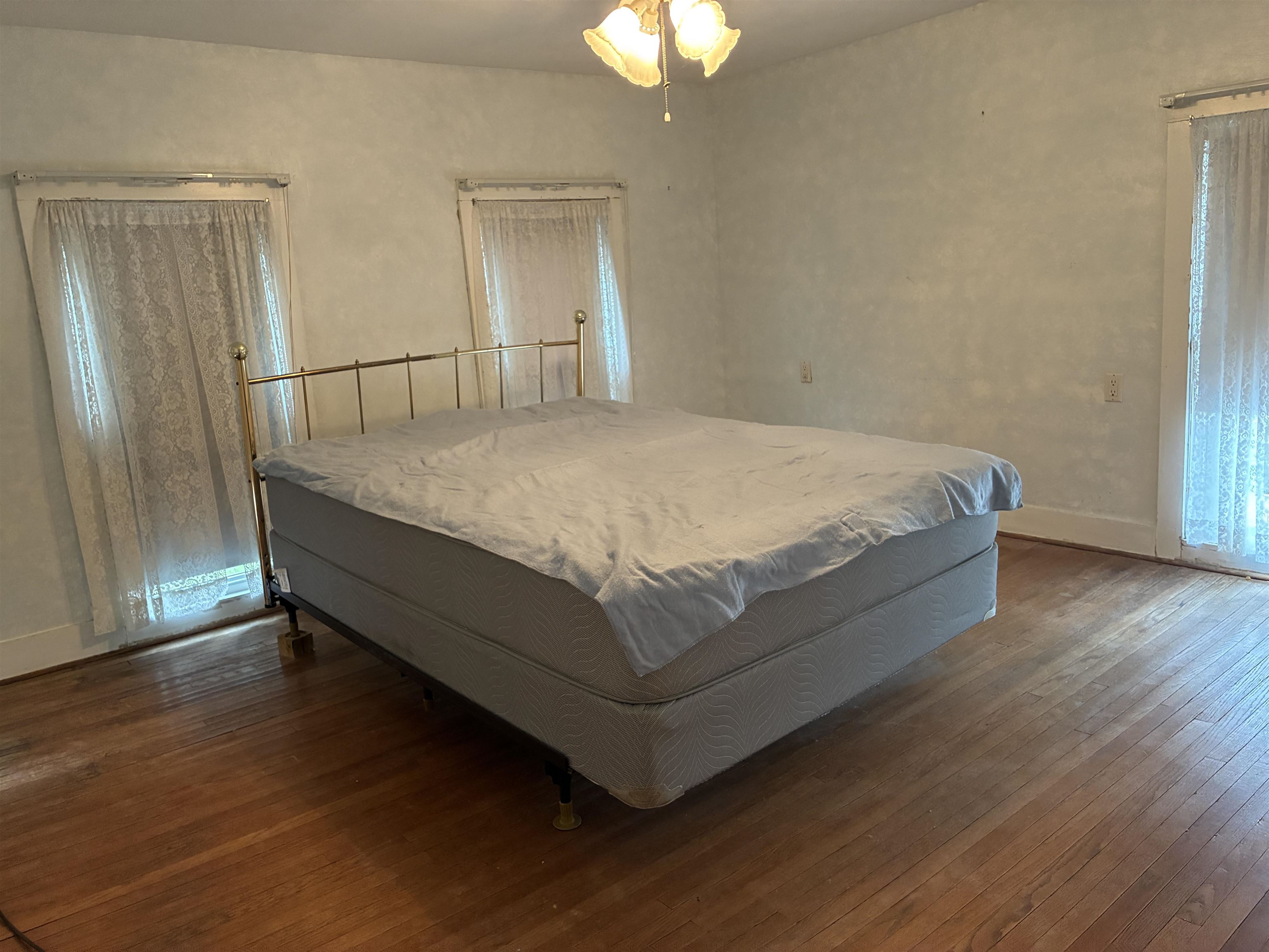 115 North Clay Street Mount Carroll, IL 61053 - Photo 33 of 61 a bed sitting in a spacious bedroom next to a window and a chandelier