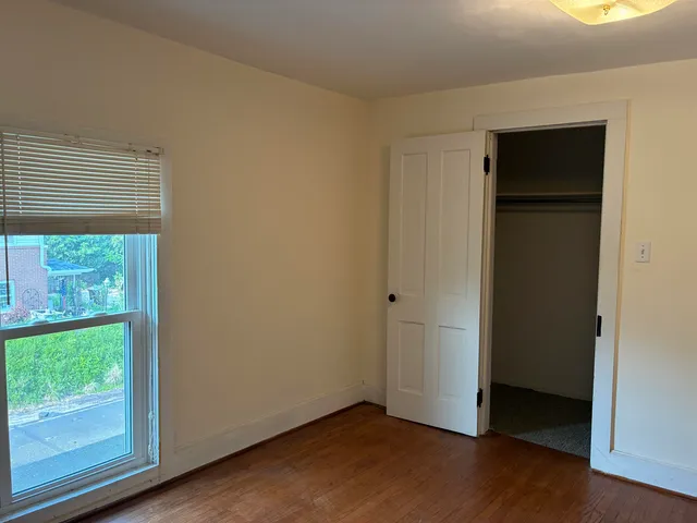 a view of a hallway with wooden floor and stairs