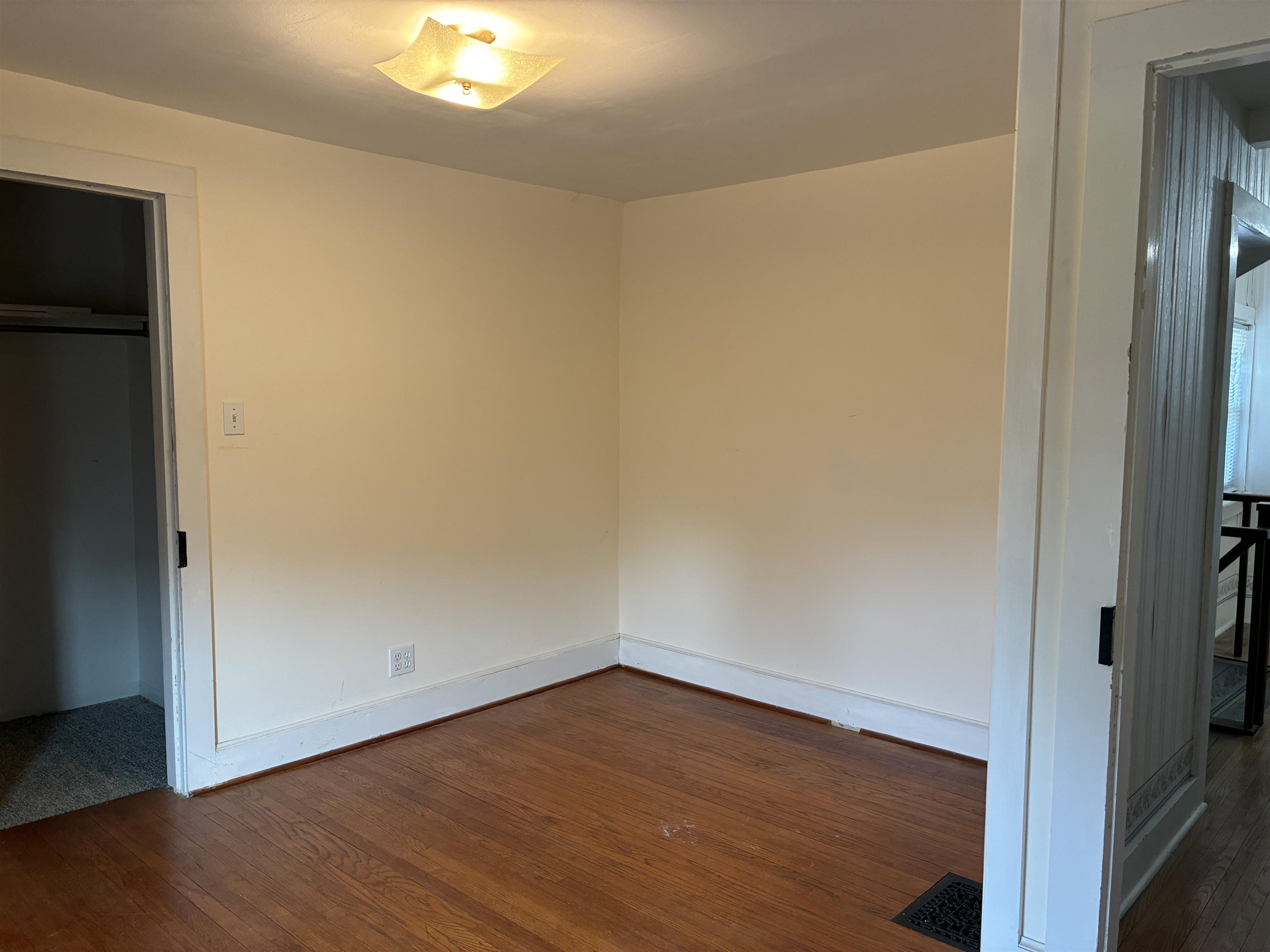 115 North Clay Street Mount Carroll, IL 61053 - Photo 39 of 61 a view of an empty room with wooden floor and a window