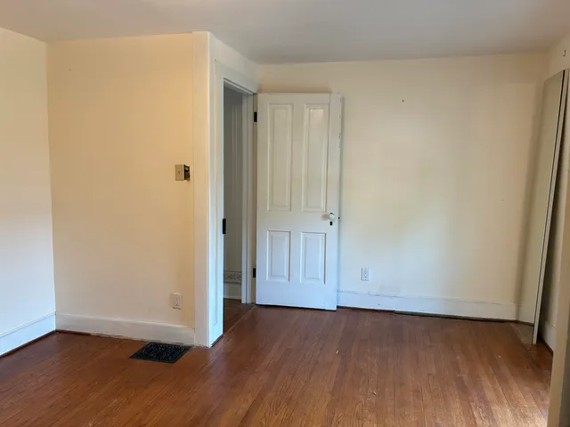 an empty room with wooden floor and door