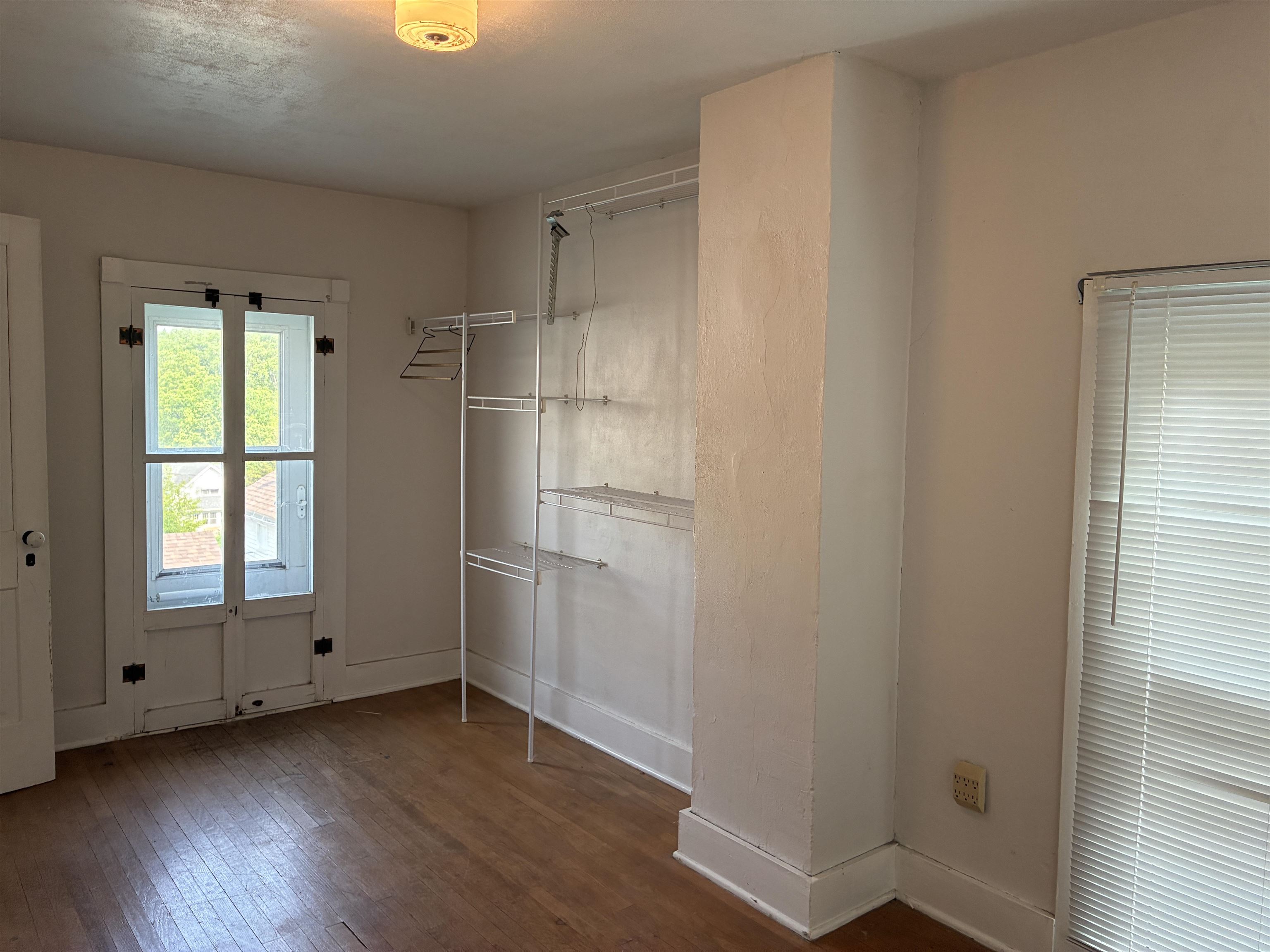 115 North Clay Street Mount Carroll, IL 61053 - Photo 44 of 61 a view of an empty room with wooden floor and a window