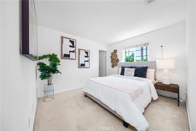 a bedroom with a large bed and a potted plant