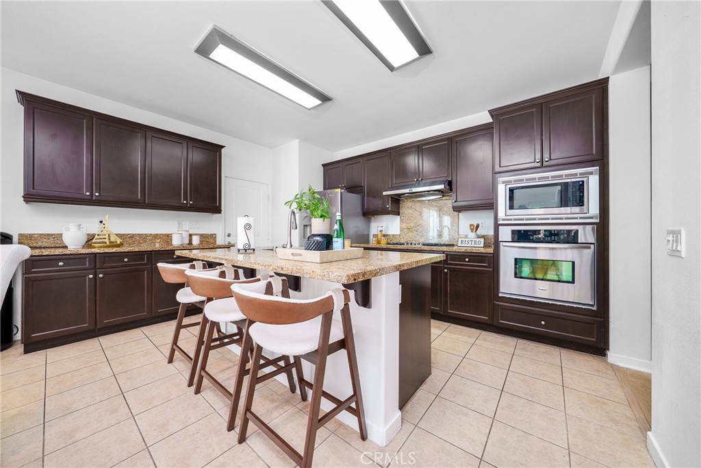 907 North Cornejo Way Azusa, CA 91702 - Photo 7 of 22 a kitchen with kitchen island granite countertop a stove a sink and a refrigerator