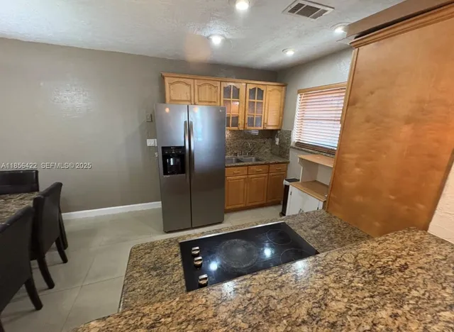 a view of a refrigerator in kitchen and wooden floor