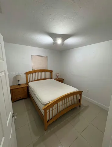 a bedroom with a bed and a lamp on desk