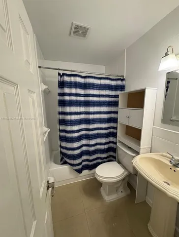 a bathroom with a granite countertop toilet a sink and a mirror