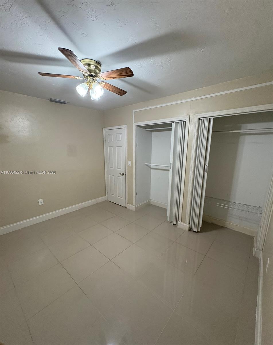 3480 Northwest 208th Street Miami Gardens, FL 33056 - Photo 7 of 7 an empty room with closet and a ceiling fan