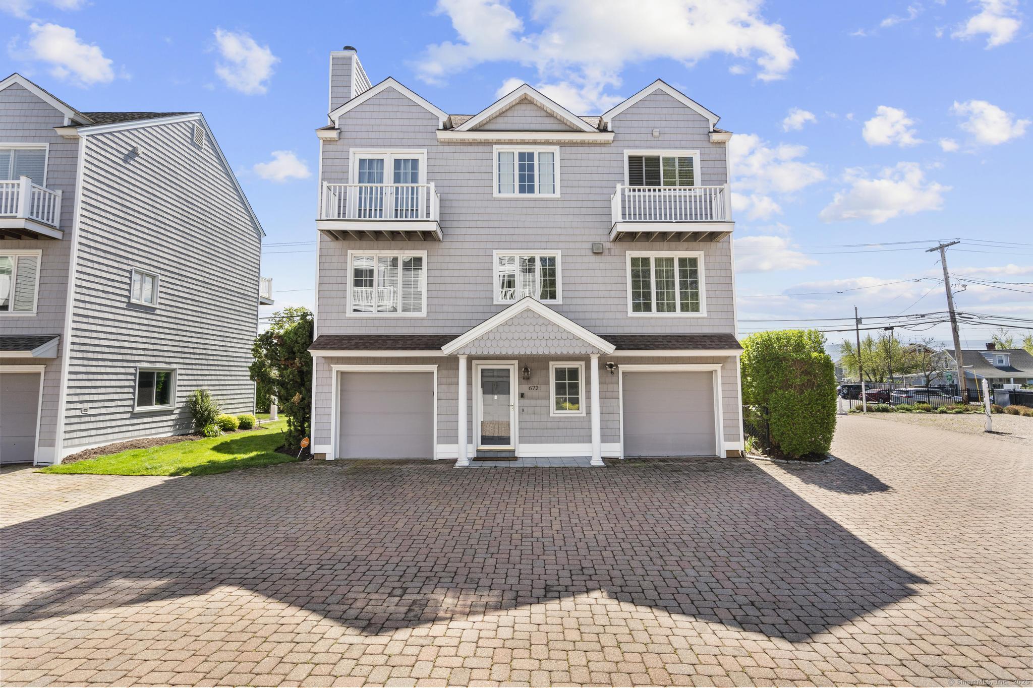 a front view of a house with a yard and potted plants