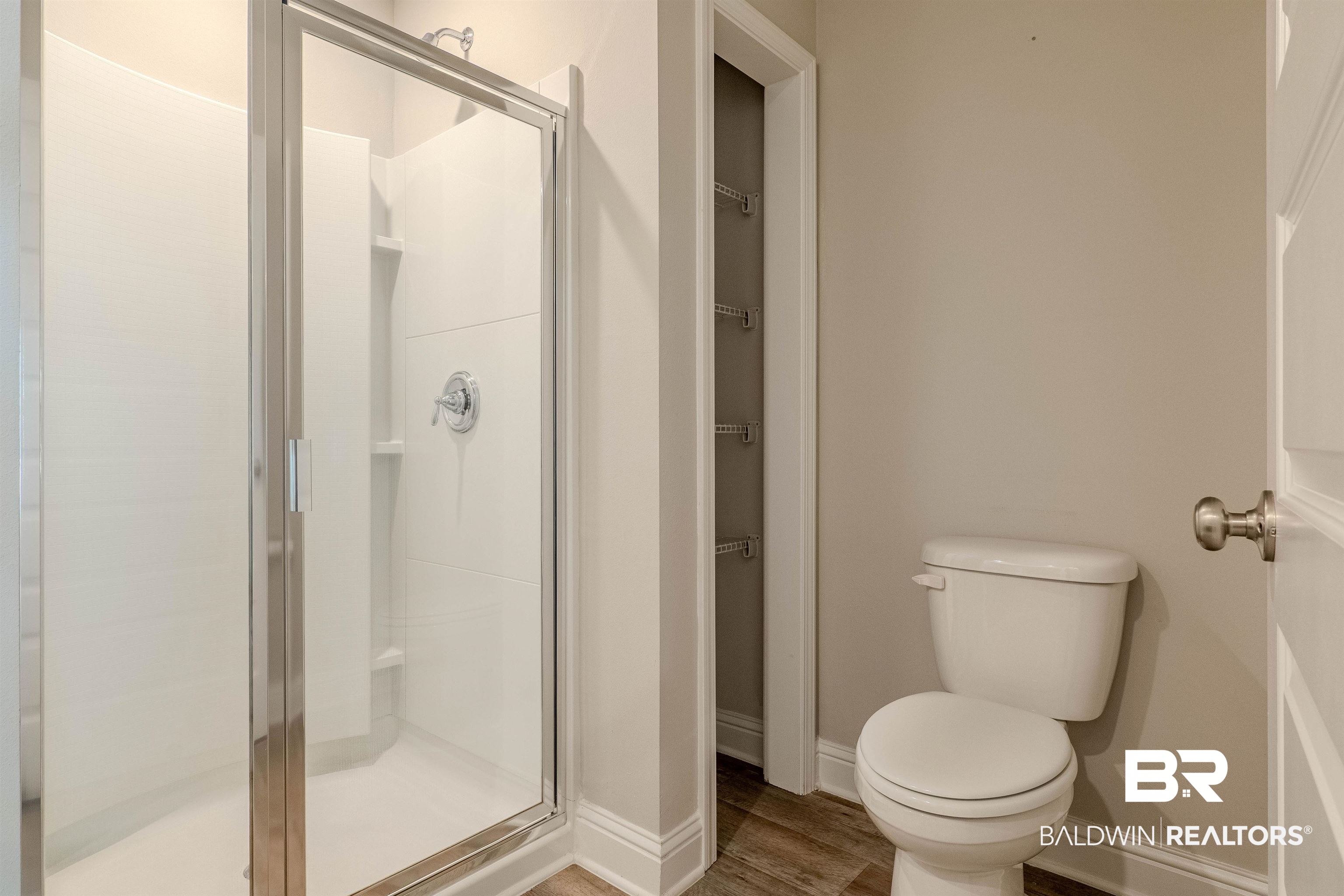 25806 Pollard Road, Unit 32 Daphne, AL 36526 - Photo 14 of 23 Bathroom featuring hardwood / wood-style flooring, a shower with door, and toilet