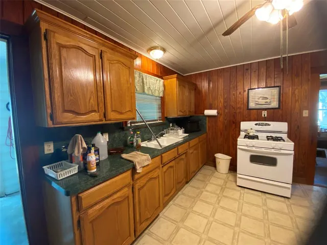 a kitchen with stainless steel appliances granite countertop a sink stove and cabinets