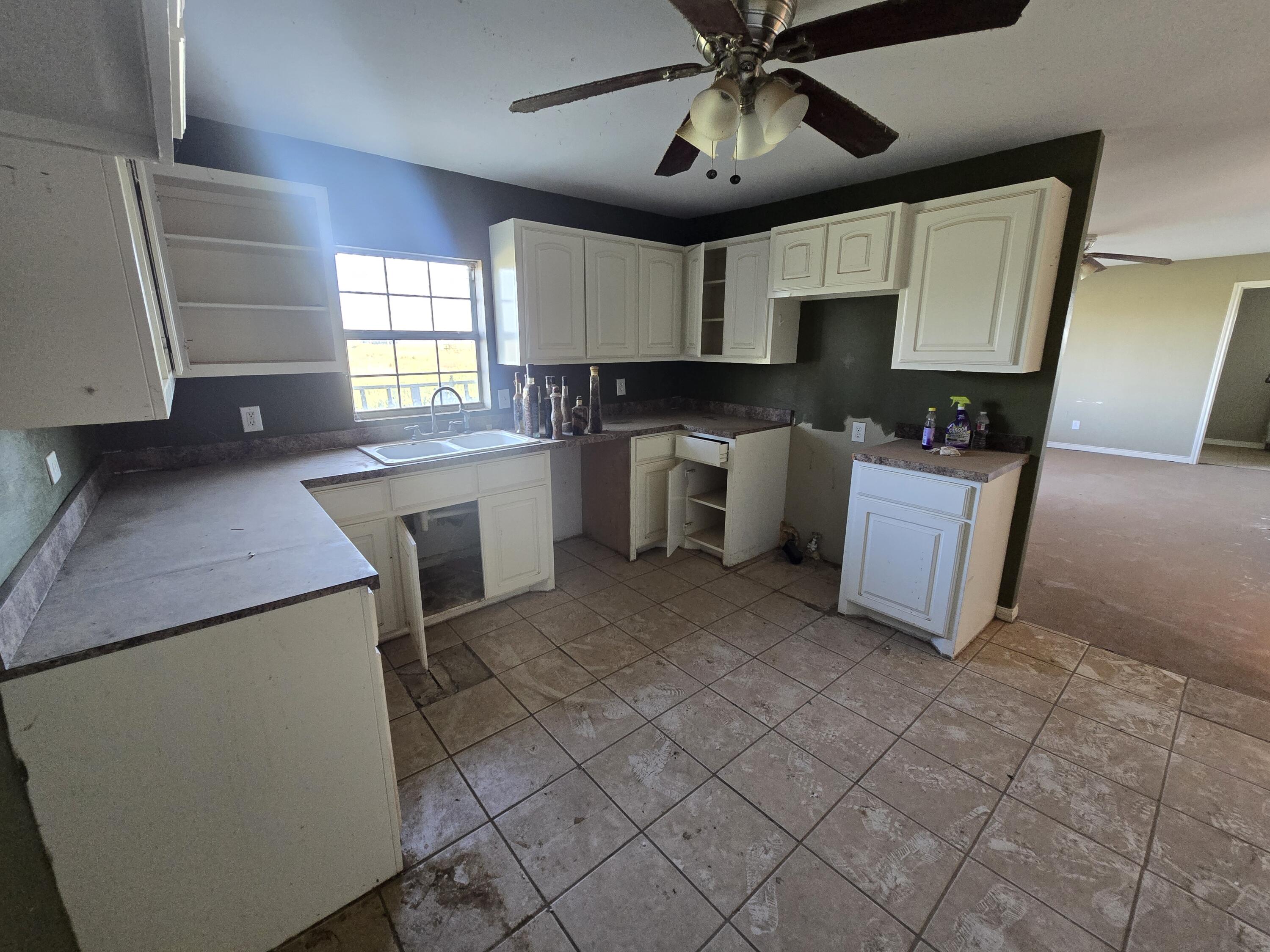 1611 County Road 50 Plainview, TX 79072 - Photo 4 of 11 a kitchen with cabinets and window